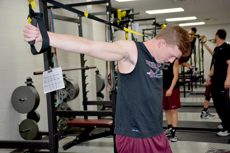 Graham Thomas/Siloam Proud Siloam Springs senior basketball player Harrison Kretzer works with resistance bands during a weight-training session back in May.
