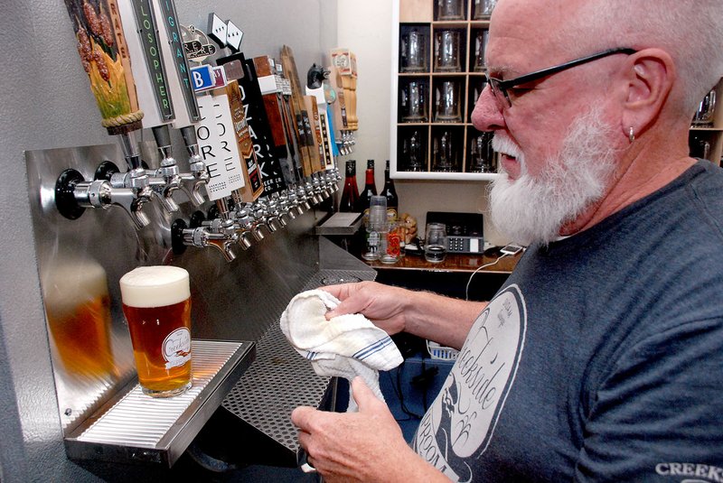 Jeff Della Rosa/Special to Siloam Proud Owner Keith Rutledge finishes a pour from the tap. The taproom has 21 Arkansas beers on tap.