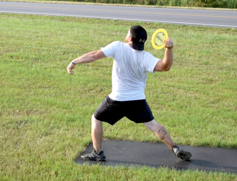 Photo by Mike Eckels From about 30 feet away from the goal, Matt LeGrand launches his putter disc toward the net during a round of Frisbee golf on the new nine-hole course at Veterans Park in Decatur on June 23.