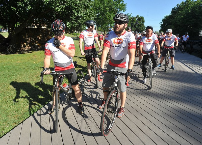 Jim Wise (left) and Tyler Emerson from the Tyson Foods headquarters prepare to join hundreds of other Tyson employees Tuesday as they begin the Miles That Matter fundraiser encouraging employees to bike, run and walk on the Razorback Greenway to help the Northwest Arkansas Food Banks.