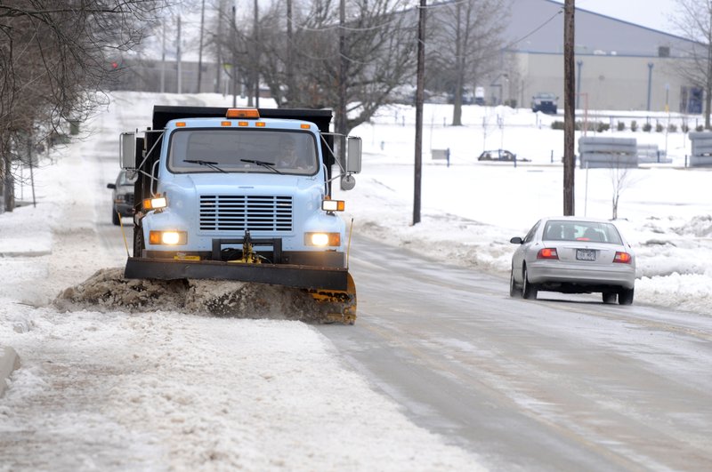 A Rogers snow plow clean Fifth Street Monday Feb. 7, 2011 in front of Rogers Heritage High School in Rogers. Crews worked to clean many of the side streets after a double shot of winter storms last week. 