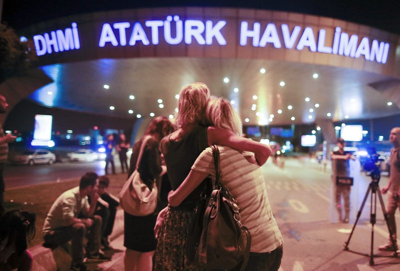 Passengers embrace each other at the entrance to Istanbul's Ataturk airport, early Wednesday, June 29, 2016 following their evacuation after a blast. Suspected Islamic State group extremists have hit the international terminal of Istanbul's Ataturk airport, killing dozens of people and wounding many others, Turkish officials said Tuesday. Turkish authorities have banned distribution of images relating to the Ataturk airport attack within Turkey. (AP Photo/Emrah Gurel) TURKEY OUT