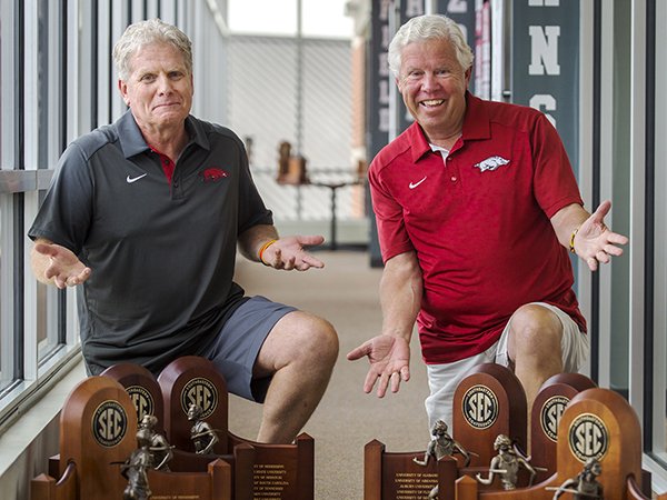 Arkansas track coaches Chris Bucknam, left, and Lance Harter pose with their SEC championship trophies won during the 2015-16 year. 