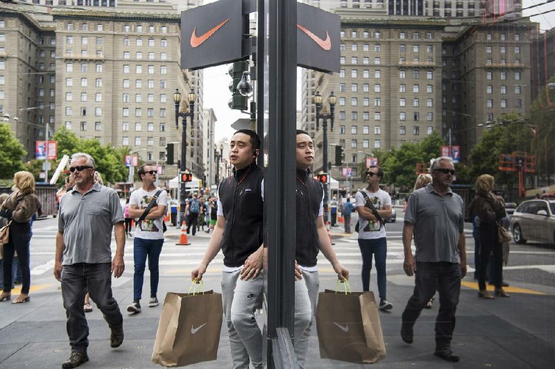 A shopper exits a Nike Inc. store in San Francisco earlier this month. Consumer spending increased 0.4 percent in May, the Commerce Department said Wednesday. 