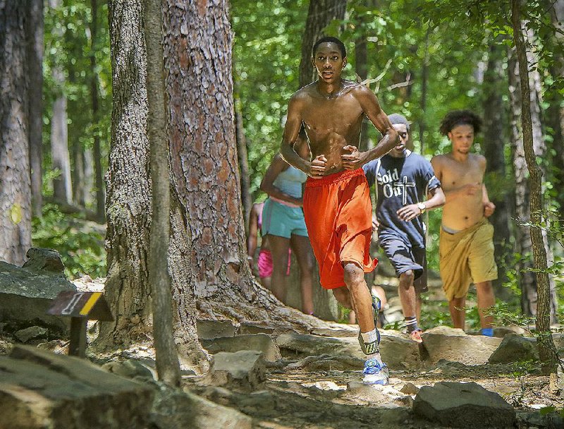 Kaleb Hughley leads members of a youth group from Hot Springs’ First Lutheran Church down a trail Wednesday afternoon at Pinnacle Mountain State Park. The park and other destinations in the state are preparing for an influx of visitors over the Fourth of July weekend.