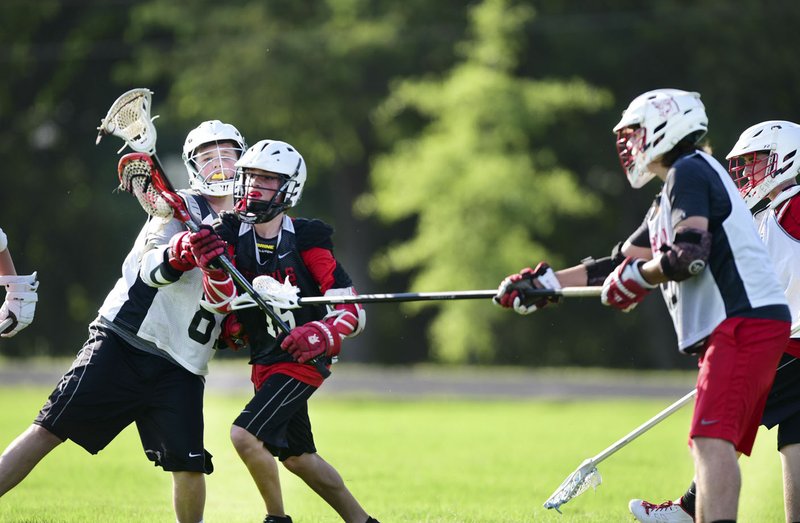 Noah Ballard (Left to Right) tries to block Kyle Salezer along with teammates Hunter Ricks and Caden McCarty while Ballard runs to the goal with the ball, Sunday June 19, 2016 during a pick up Lacrosse on a field at Tennis Russell Primary School in Bentonville. Lacrosse is one of the fastest growing national sports and is becoming more popular in Northwest Arkansas.