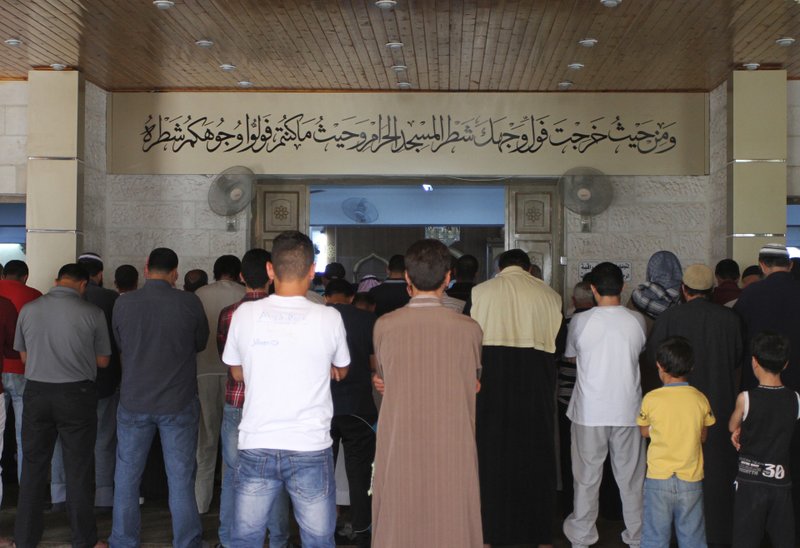 In this Sunday, June 19, 2016 photo, men pray inside the al-Makhtoum mosque in Zarqa, Jordan during the funeral of Nasser Idreis, an alleged Islamic State sympathizer who died serving a three-year prison sentence. 