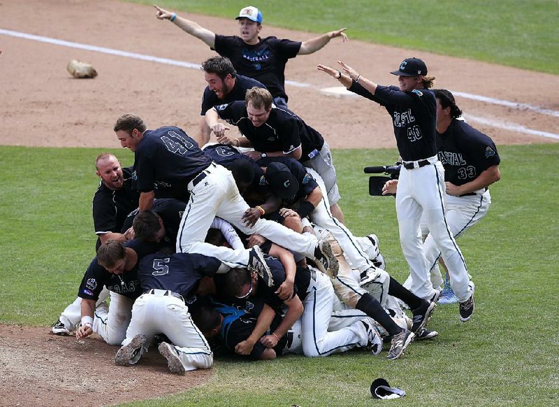 Coastal Carolina players pile up near the pitcher’s mound after the Chanticleers used a four-run sixth inning to beat Arizona 4-3 in Game 3 of the College World Series on Thursday afternoon to win the program’s first national title.