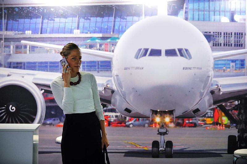 An attendee at the International Air Transport Association symposium in Dublin last month stands in front of a photo of a Boeing 777 aircraft. Boeing has been offering an expanded version of the 777 to several airlines.