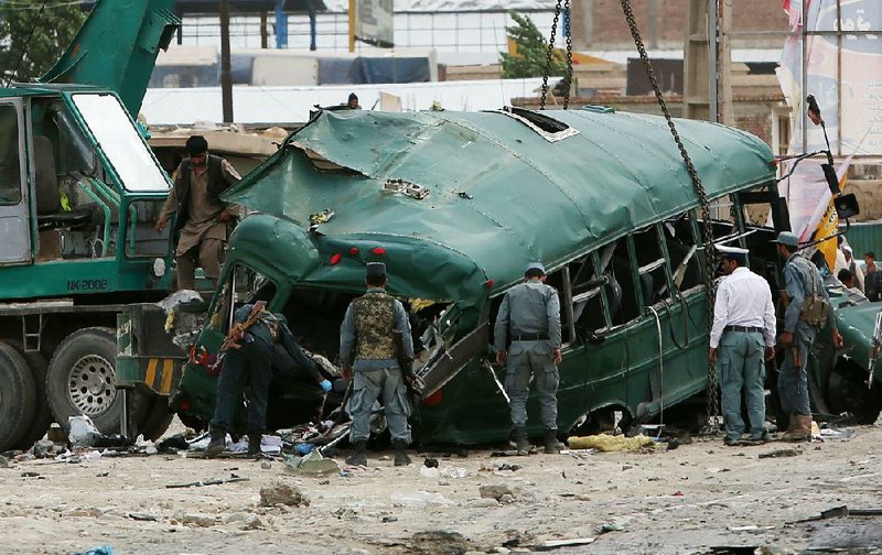 Afghan security forces inspect the site of a twin suicide attack Thursday that targeted a police convoy near Kabul. 