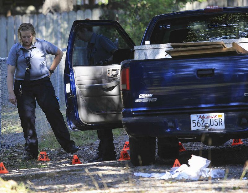 Little Rock Police Department crime scene investigators work Thursday morning at the scene of a shooting that injured three people near 32nd and Zion streets. 