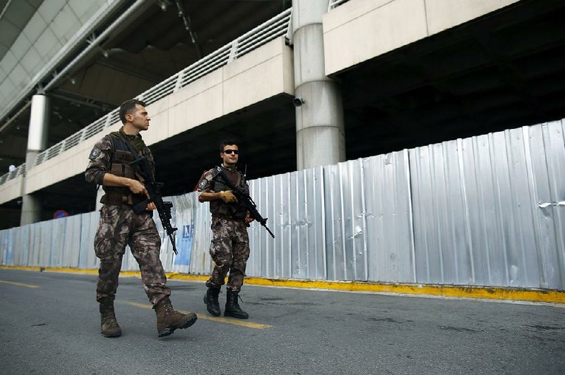 Police patrol as mourners gather Thursday at Ataturk Airport in Istanbul for a memorial service for victims of the suicide attacks Tuesday at the airport. 