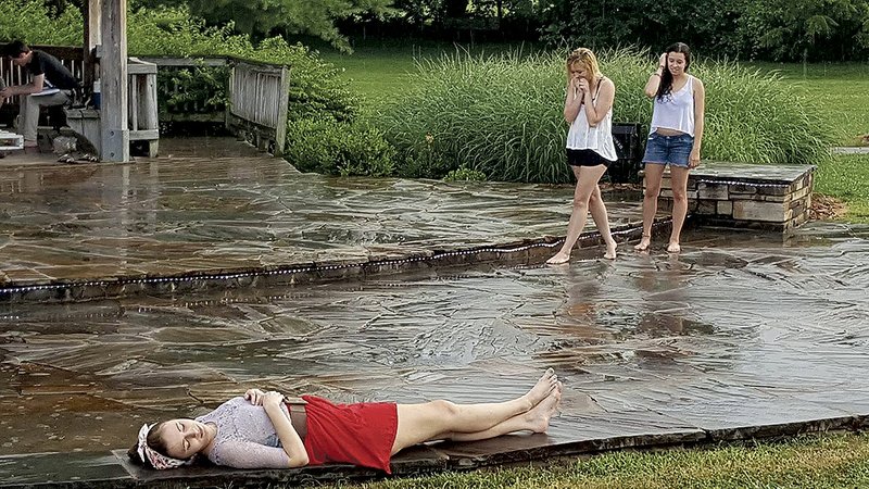 After a pop-up thunderstorm, Haley Zega (lying front), Maggie Wood and Allegra Rodriguez-Shivers continue
rehearsal for the Crude Mechanicals’ production of “A Midsummer Night’s Dream,” being presented July 8-12 at Gulley Park.