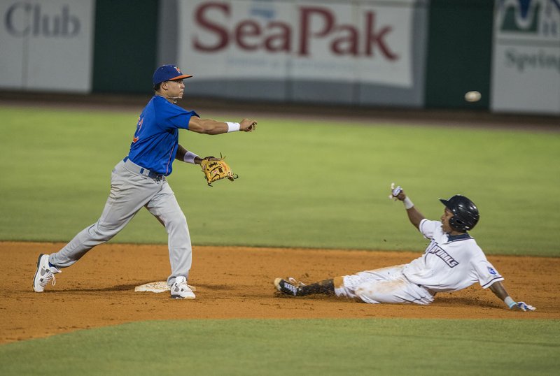 Terrance Gore of Northwest Arkansas slides after being forced out by Yairo Munoz of Midland on the front end of a double play Thursday at Arvest Ballpark in Springdale.