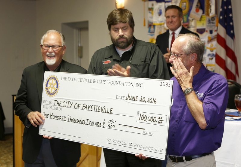 City of Fayetteville mayor Lioneld Jordan (from right) wipes a tear from his eye Thursday, June 30, 2016, after receiving a check for $100,000.00 from Harrison Pittman, president elect, and Ray Boudreaux, out going president, with the Rotary Club of Fayetteville at Mermaids Seafood Restaurant in Fayetteville. The donated money will go to the purchase and construction of a new playground at new Regional Park in Fayetteville. Jordan announced the that the park will open Thursday, August 20, 2016.