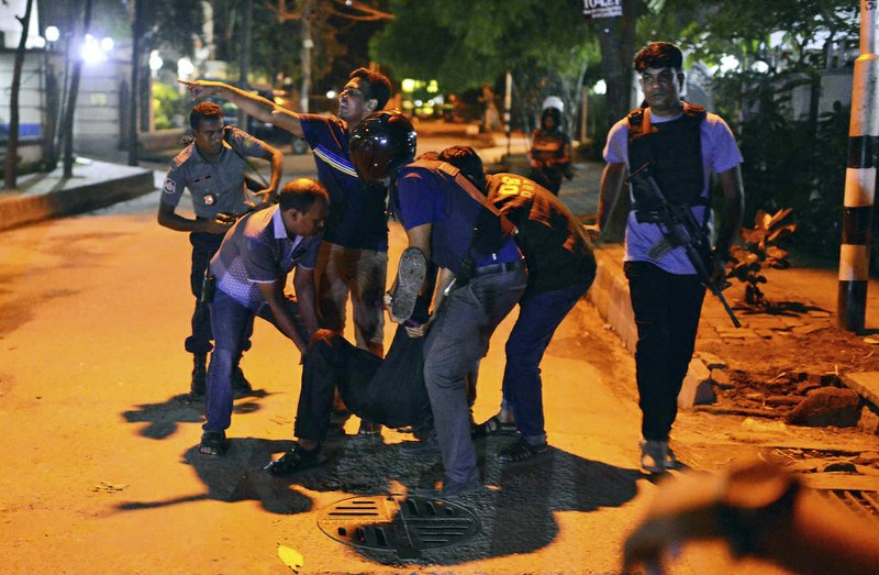 People help an unidentified injured person after a group of gunmen attacked a restaurant popular with foreigners in a diplomatic zone of the Bangladeshi capital Dhaka, Bangladesh, Friday, July 1, 2016. A group of gunmen attacked a restaurant popular with foreigners in a diplomatic zone of the Bangladeshi capital on Friday night, taking hostages and exchanging gunfire with security forces, according to a restaurant staff member and local media reports. 
