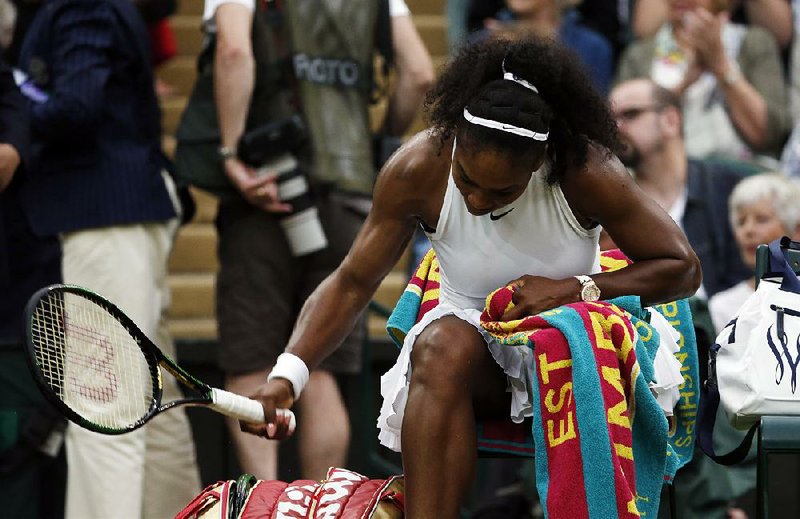 American Serena Williams smashes her racket on the turf after losing her first set to countryman Christina McHale during their women’s singles match at Wimbledon in London on Friday. Williams went on to win the match 6-7 (7), 6-2, 6-4 to advance to the third round.