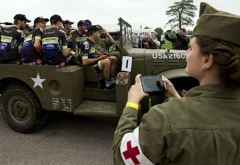 Cyclists ride in a World War II vehicle ahead of the Tour de France, which begins today at Mont-Saint-Michel and ends at Utah Beach, a landing site for Allied troops on D-Day.