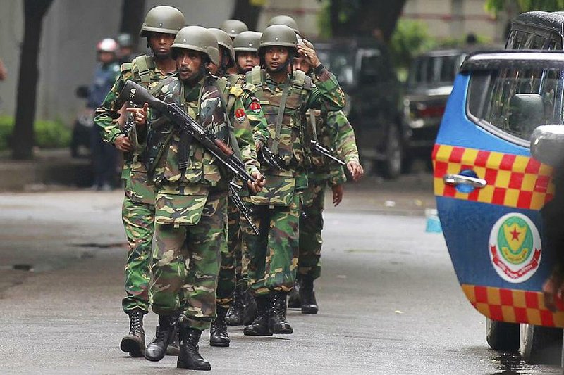 Bangladeshi soldiers leave the area today after an operation against militants who seized people in a restaurant.