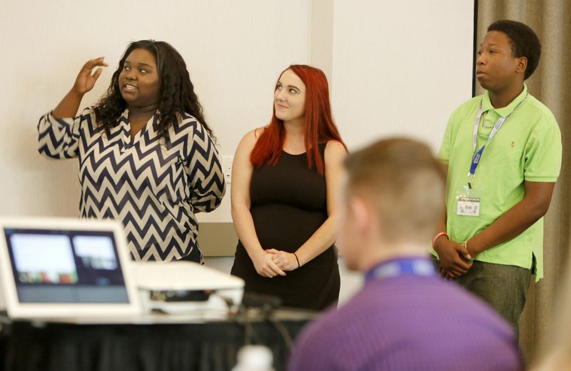 Kira Patrick (from left), 17, Katie Lewis, 16, and Jamal Oliver, 16, introduce their business idea Friday with teammates Kira-Amari Allen, 18, Kiya Livingston, 16, to the judges at the end of the weeklong Teen Entrepreneur Camp at the Chancellor Hotel in Fayetteville. The five won the competition and $500 for their GPS-based stickers to locate lost items called Stick-It.