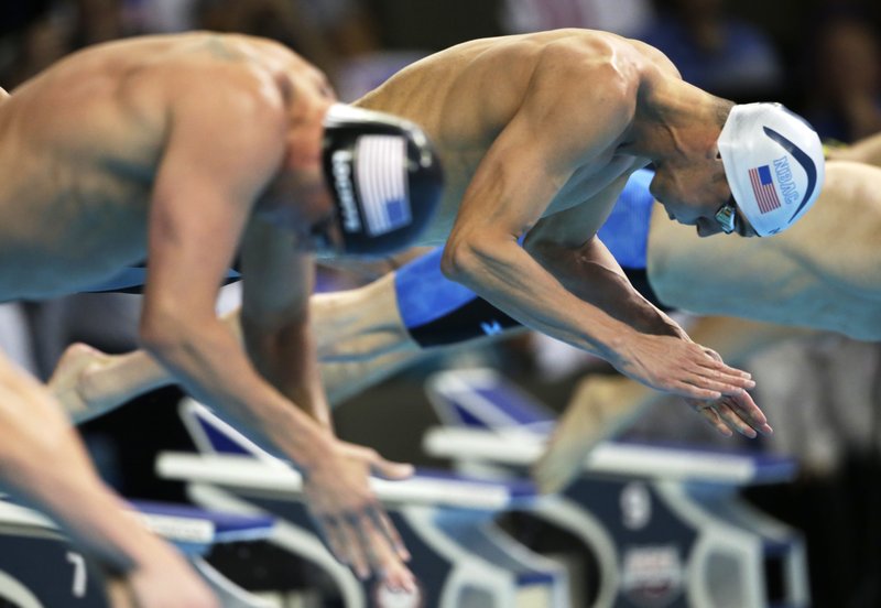 Michael Phelps, right, dives at the start of the men's 200-meter individual medley final at the U.S. Olympic swimming trials, in Omaha, Neb., Friday, July 1, 2016. Phelps won the race. 