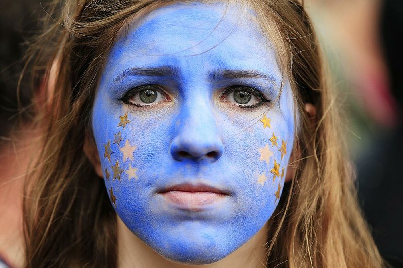 A woman, her face painted to resemble the European Union flag, takes part Saturday in a march to Parliament Square in London as protesters showed their support for the EU in the wake of the United Kingdom’s decision to leave the bloc.