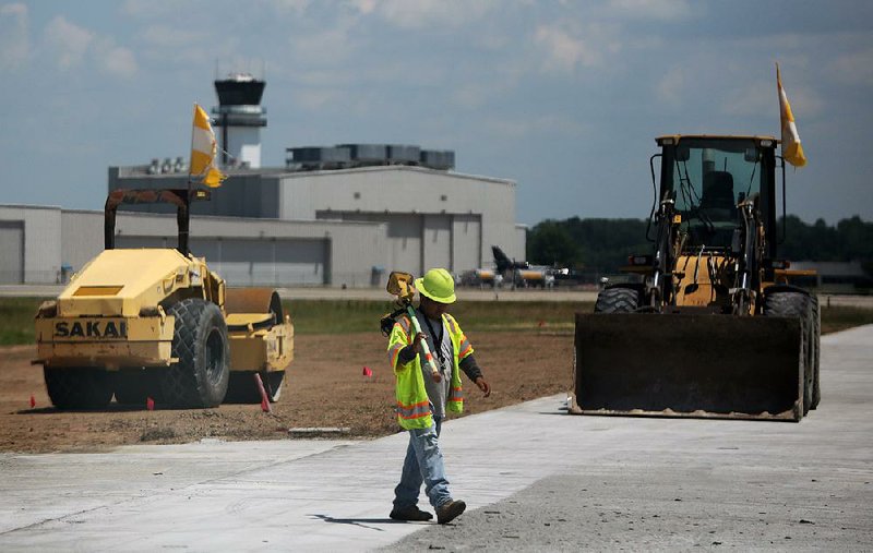 A crew works last week on one of the runways at Bill and Hillary Clinton National Airport/Adams Field in Little Rock.