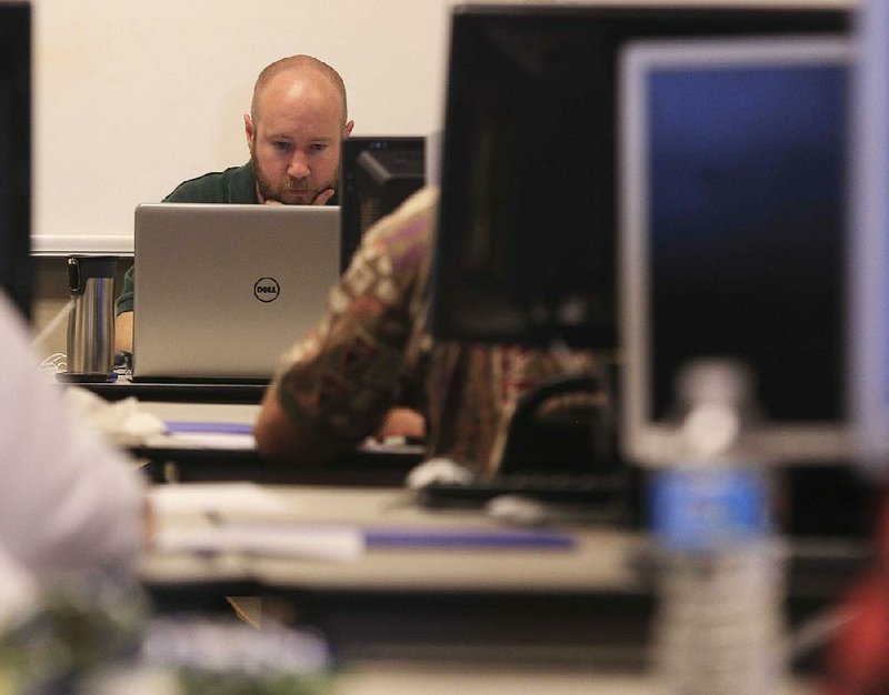 Mitchell Minyard, a staff member in the secretary of state’s office, works Friday to verify signatures for ballot initiatives. 