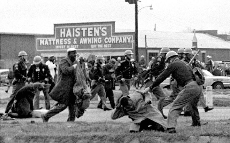 An Alabama state trooper clubs civil rights activist John Lewis during the March 7, 1965, march in Selma. “When you see something that is not right, not fair, not just, you have to do something about it in a nonviolent fashion, and that’s what we did,” Lewis said last month after leading the June 22 sit-in by Democratic House members  seeking to hold votes on gun legislation.