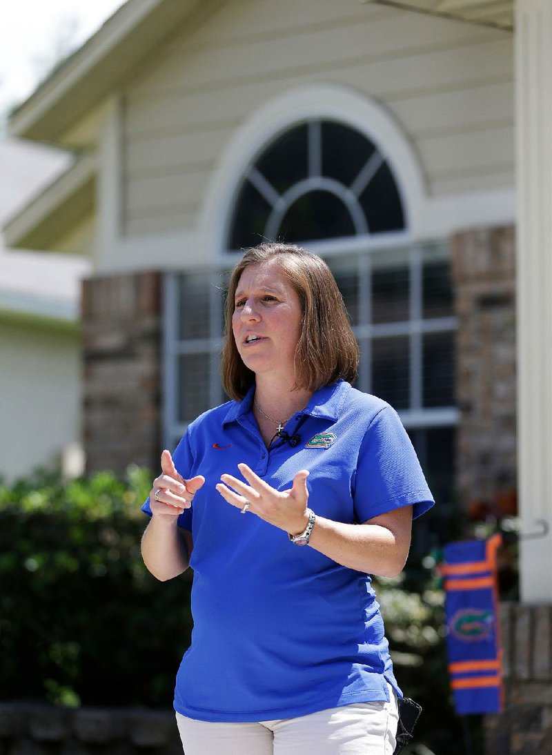 Homeowner Michelle Harner stands in front of her house in the Piedmont Park neighborhood of Apopka, Fla. 