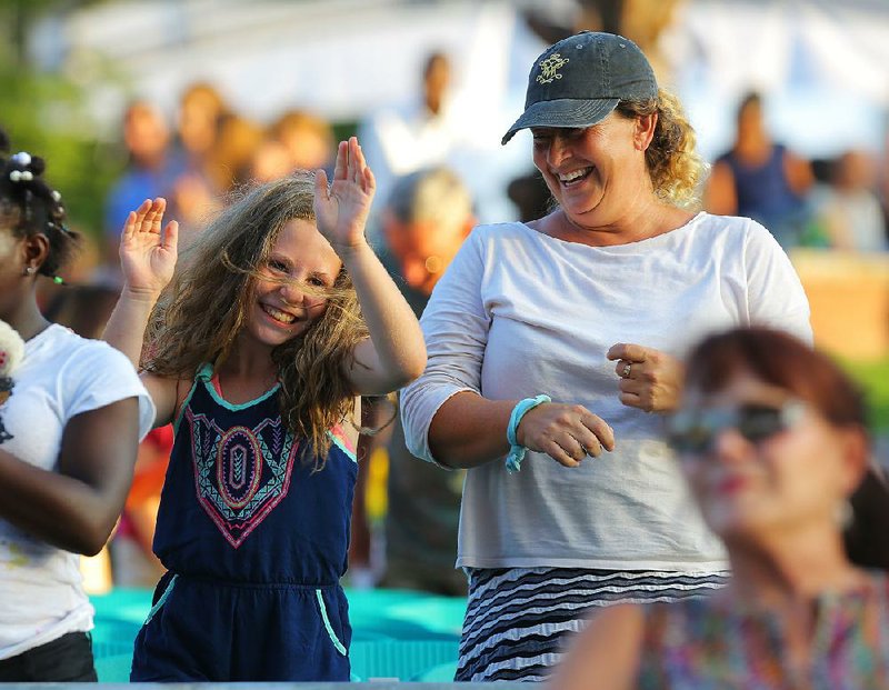 Lena Nelson, 9 (left), dances with her mother, Lane Nelson, to music before the Arkansas Symphony Orchestra performs during the 33rd Annual Pops on the River event along the Arkansas River on Monday evening in Little Rock.
