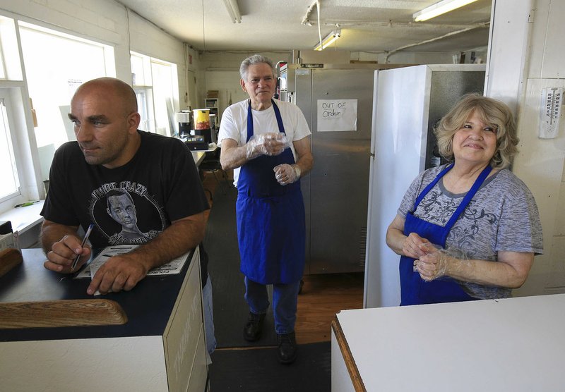 Bill (center) and Billie Huey (right) talk with customers Wednesday as Donny Kennedy waits to take orders at the Fourche Dam Dairy Bar. The Hueys retired and Thursday was their last day to be open for business.