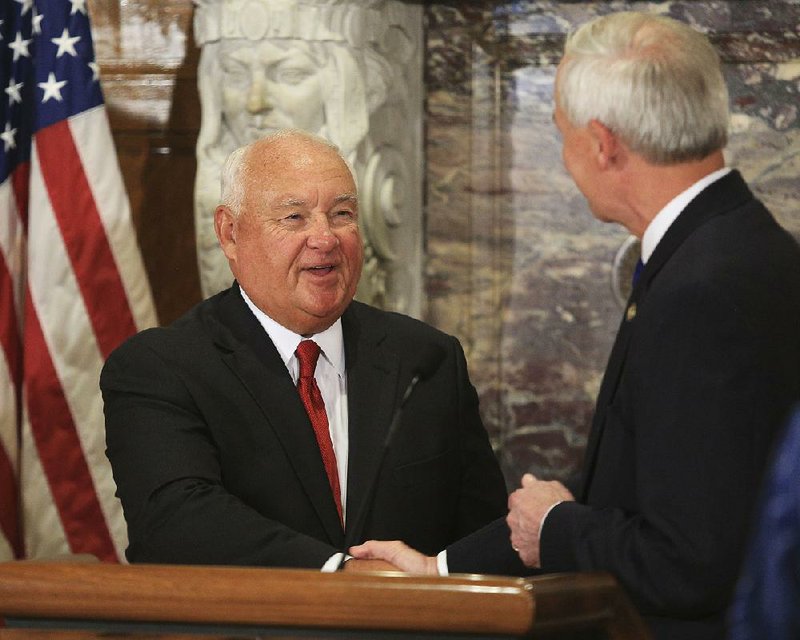 Bobby Martin (left) is congratulated by Gov. Asa Hutchinson after being named a new commissioner of the Arkansas Game and Fish Commission during a news conference Thursday.