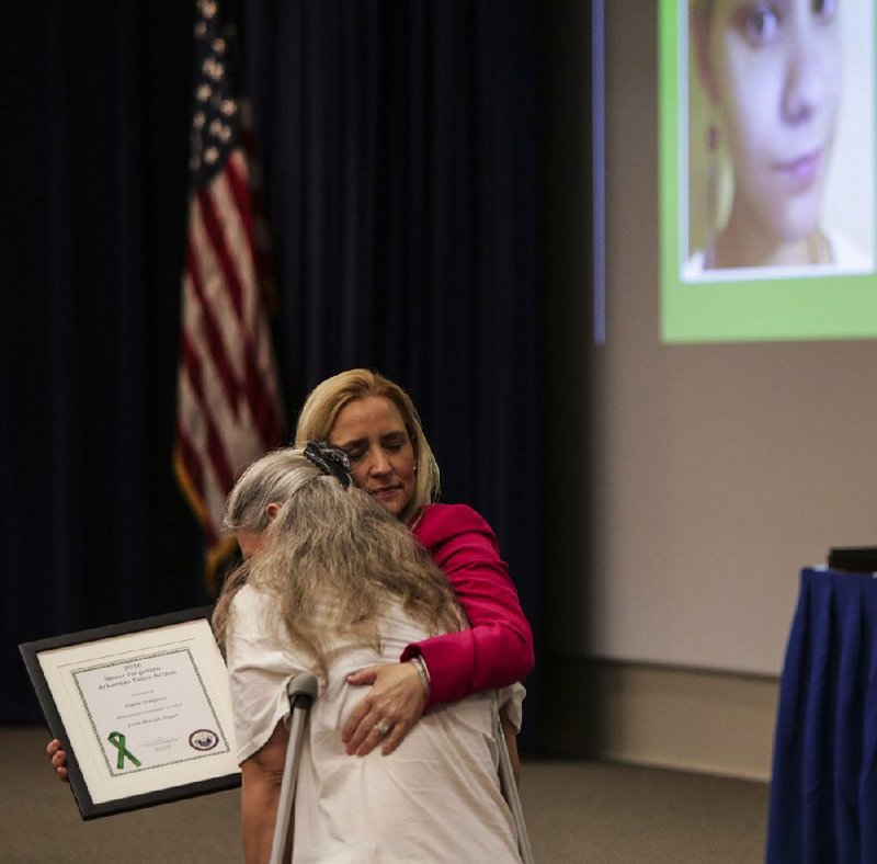 Judy Compton (left) gets a hug from Attorney General Leslie Rutledge during the fifth annual Never Forgotten event at Camp Robinson on Thursday in North Little Rock. 