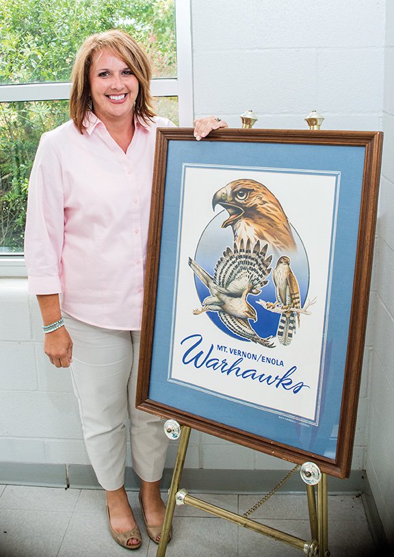 Jennifer Raby, the new Mount Vernon-Enola High School principal, stands by a framed Warhawks picture in the school. Raby, 42, was the high school counselor and was hired as principal, beginning July 1. She replaced Chris Nail, who left to become superintendent of the Rose Bud School District.