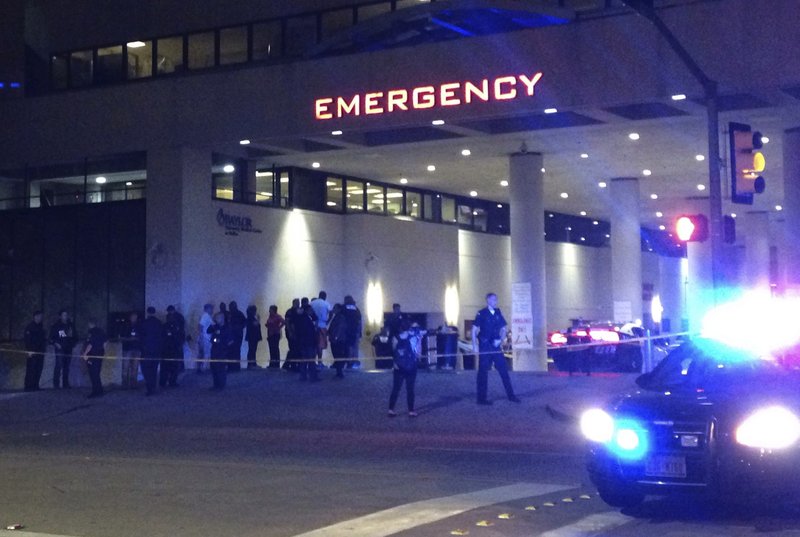 Police and others gather at the emergency entrance to Baylor Medical Center in Dallas, where several police officers were taken after shootings Thursday, July 7, 2016.