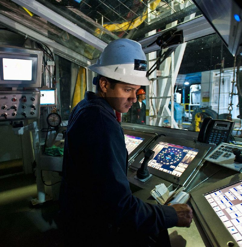 Driller Adrian Vallarta runs the Orion Drilling Co.’s Perseus drilling rig from the driller’s console near Encinal in Webb County, Texas, in this file photo. 