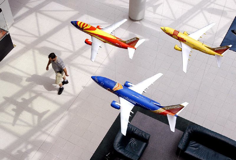 Models of Boeing 737 planes hang in the lobby of Southwest Airlines headquarters in Dallas in this file photo. Boeing will test a nonstick coating on an Embraer E-175 jet, not one of its own.
