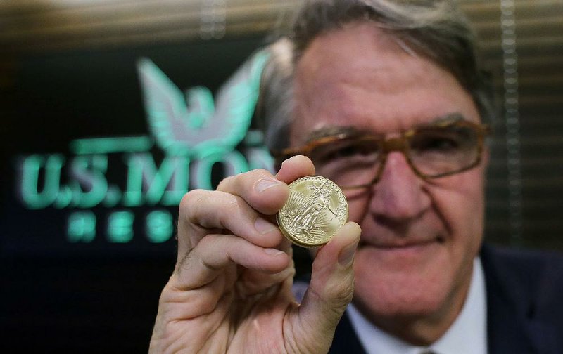 Philip Diehl holds a 1 ounce gold coin at his office in Austin, Texas, earlier this month. The price of gold has been rising recently as investors look for safe places to invest their money.
