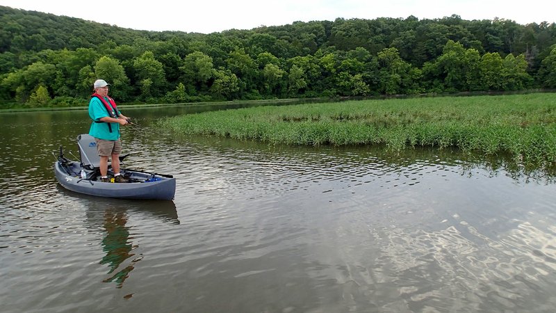 Lake Sequoyah, on the southeastern edge of Fayetteville, has lots of vegetation which makes fine habitat for black bass and other game fish. Mike McBride fishes near an island of grass for black bass. It's easy to cover the whole lake in a canoe or kayak.