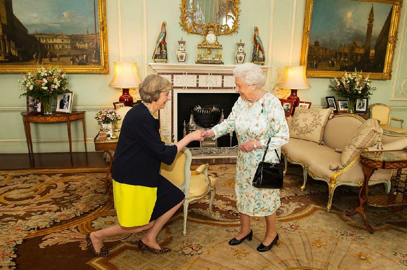 Theresa May curtsies before Queen Elizabeth II on Wednesday at Buckingham Palace, where the queen invited her to become prime minister after David Cameron’s ceremonial resignation at the palace.