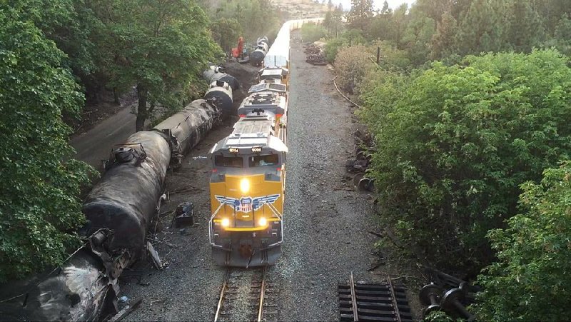 Charred tanker cars line the railroad track in the Columbia River Gorge near Mosier, Ore., in this photo taken by drone operator Brent Foster on June 6. Federal rules that allow companies to phase in upgrades to their aging fleet of oil- and ethanol-carrying cars mean some of them will remain in service for another 15 years. 