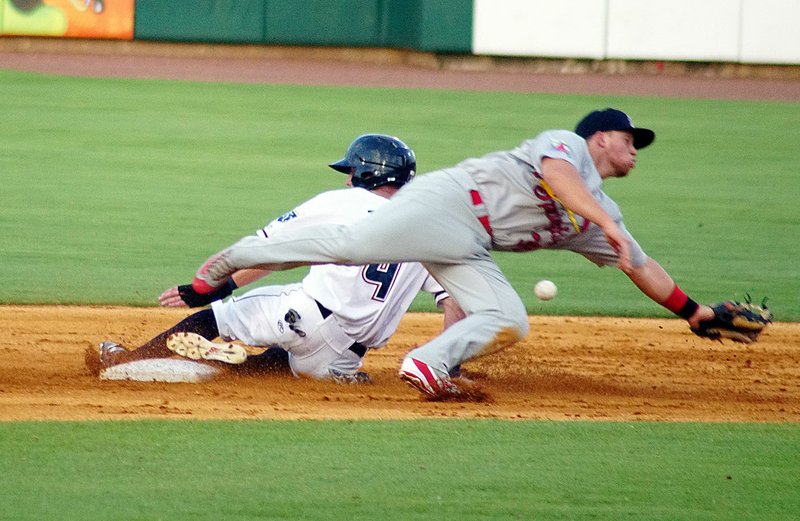 Courey Toups of the Naturals (left) slides into second for a steal as Allen Staton of Springfield is pulled off the bag by the throw from the catcher Wednesday at Arvest Ballpark in Springdale.