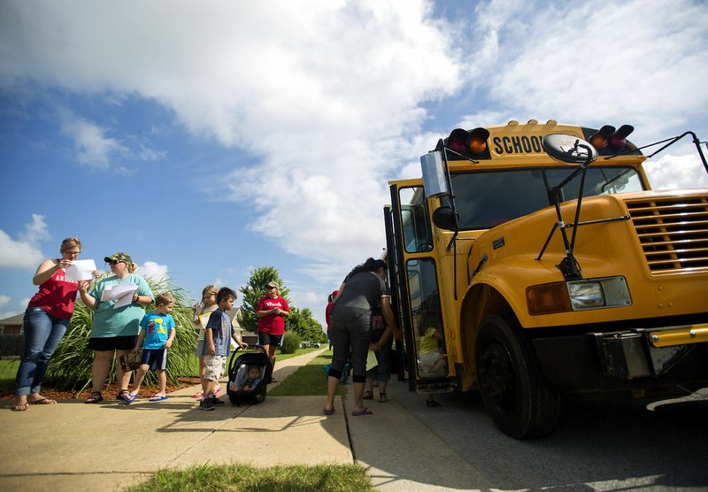 Families in the Standing Oaks neighborhood visit the Pea Ridge book bus.