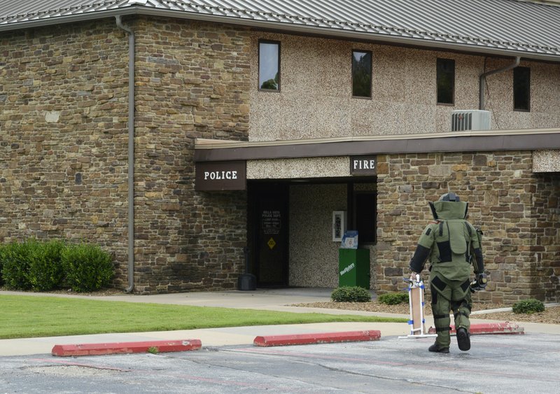 Bentonville Bomb Squad bomb technician Ryan Simmons carries a portable X-ray system into the Bella Vista police station Thursday after a man carried a briefcase into the lobby. He told an officer that he might be the victim of a scam and the briefcase might contain a bomb.