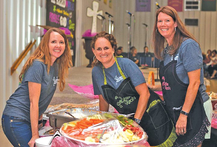 From left, Mary Medlock, Staci McHenry and Melanie Isaacs volunteer as kitchen staff during the 2015
Rock This House women’s conference, which is held annually at the Ash Flat Church of Christ.