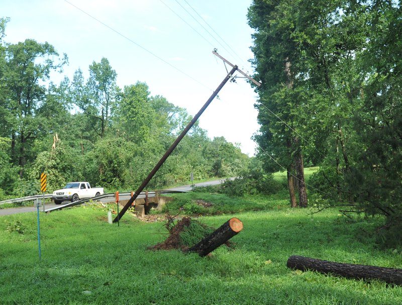 Damaged trees and power poles are strewn about the intersection of Brady Mountain Road and Simmons Trail on Friday.