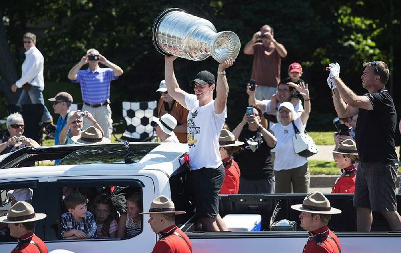 Pittsburgh Penguins center Sidney Crosby hoists the Stanley Cup during a parade through his hometown of Cole Harbour, Nova Scotia, on Saturday.
