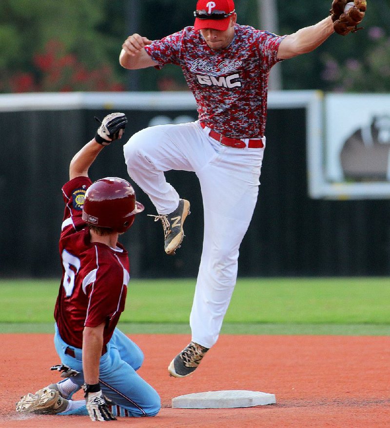 Paragould’s Layne Ditto leaps off second base after forcing out Jacksonville Tyson Flowers in Paragould’s 11-1 victory Saturday in the American Legion AAA state tournament in Conway. Ditto hit for the cycle in the victory.