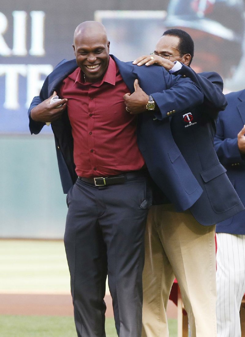 Hall of Famer Rod Carew (right) helps Torii Hunter, who retired last year, with his coat after he was inducted into the Twins Hall of Fame on Saturday in Minneapolis.